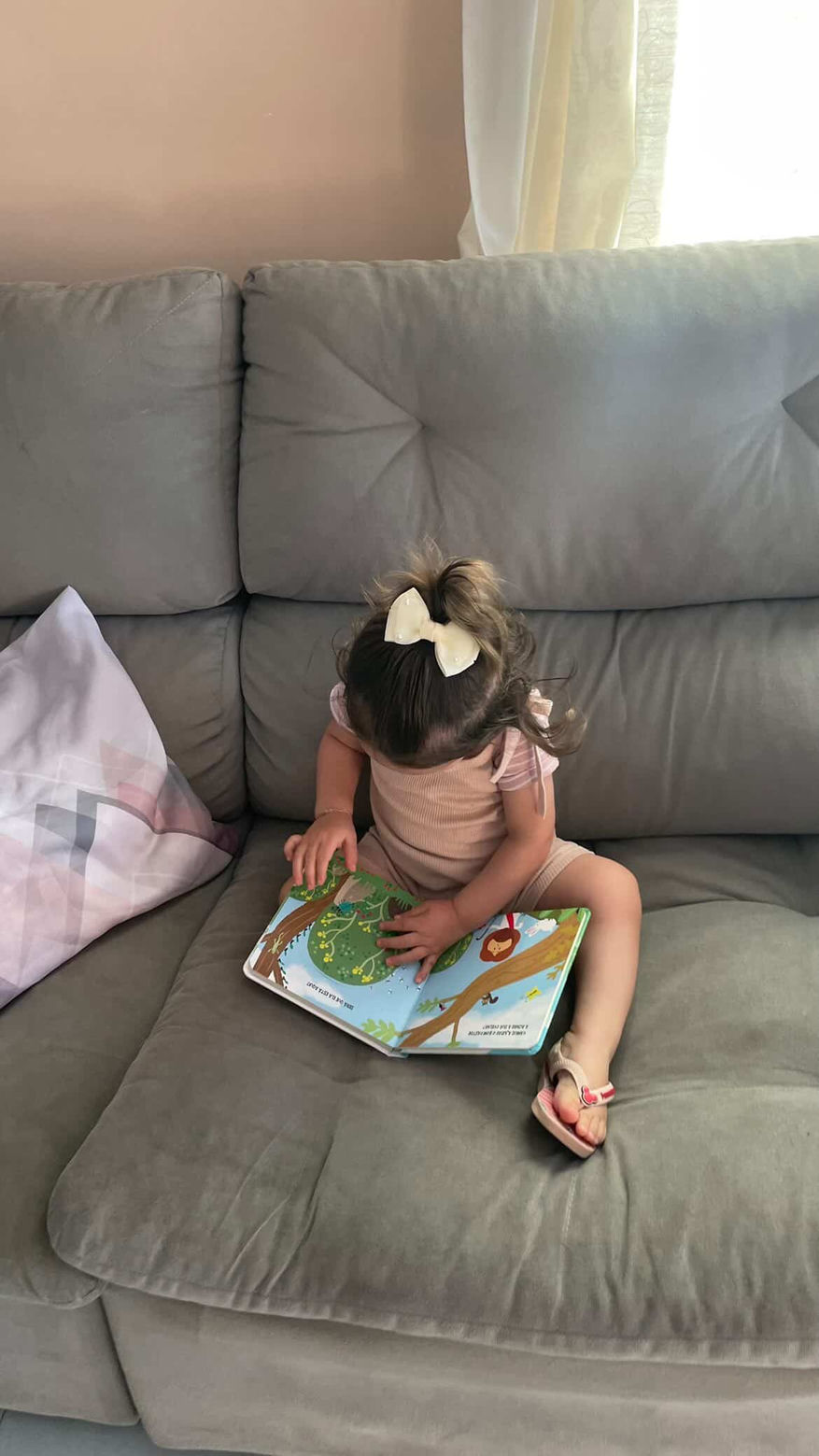 Menina lendo sozinha no sofá